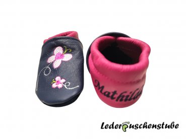Lederpuschen dunkelblau-pink mit Namen links und Datums rechte Ferse dunkelblau sowie Stickerei Schildi 2 pink-rosa-hellgrün Schmetterlinge 